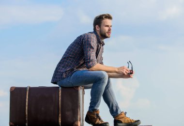 Bagaj konsepti. Bagajla seyahat et. Gezgin blogcu. Tatil zamanı. Seyahat acentesi. İnsan yolculuktan önce bavula oturur. İş gezisi. Yakışıklı bir gezgin. Klasik bavullu bir adam.