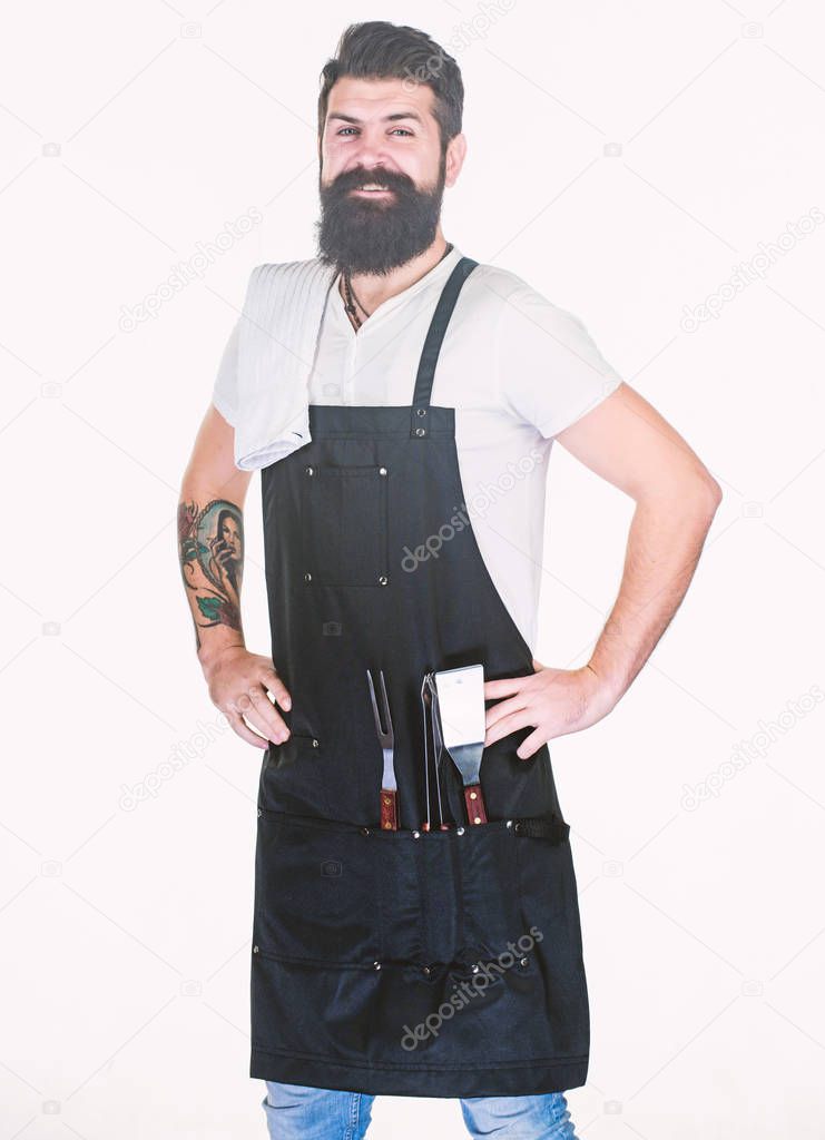 Confident and skillful. Grill master keeping his hands on hips with confidence. Master chef wearing grill apron with barbecue tools. Master of grill. Barbecue master class at grill restaurant