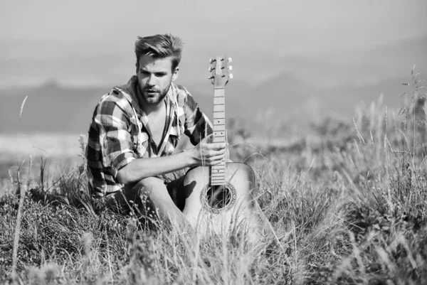 Deja que la música te lleve lejos. camping occidental y senderismo. vaquero con guitarrista acústico. sexy hombre con guitarra en camisa a cuadros. canción de música country. moda hipster. feliz y libre —  Fotos de Stock