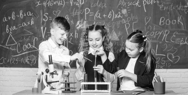 Οι μαθητές της ομάδας σπουδάζουν χημεία στο σχολείο. Τα αγόρια και τα κορίτσια απολαμβάνουν χημικό πείραμα. Οργανική χημεία είναι η μελέτη των ενώσεων που περιέχουν άνθρακα. Βασικές χημικές αντιδράσεις. Συναρπαστική χημεία — Φωτογραφία Αρχείου