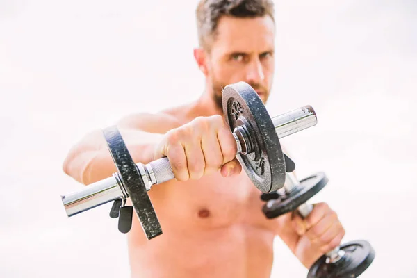 man sportsman weightlifting. athletic body. Dumbbell gym. success. Perfect biceps. Muscular man exercising in morning with barbell. fitness and sport equipment. Warming up for a workout routine