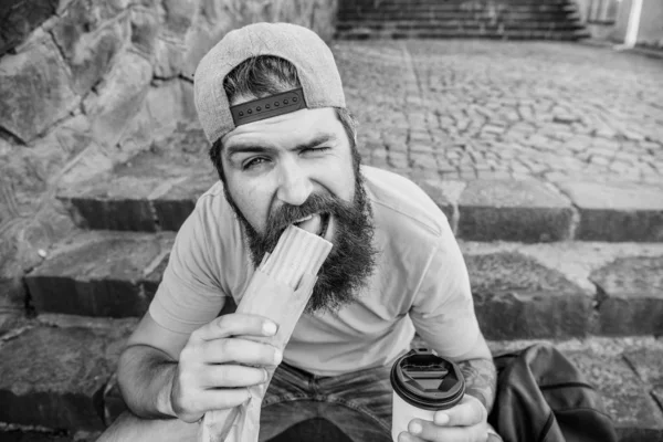 Melhores ingredientes, melhor cozinha. Homem barbudo comendo comida rápida insalubre. Caucasiano viajante cara desfrutando de cozinha de rua. Hipster ter cozinha tradicional cachorro-quente durante o descanso — Fotografia de Stock