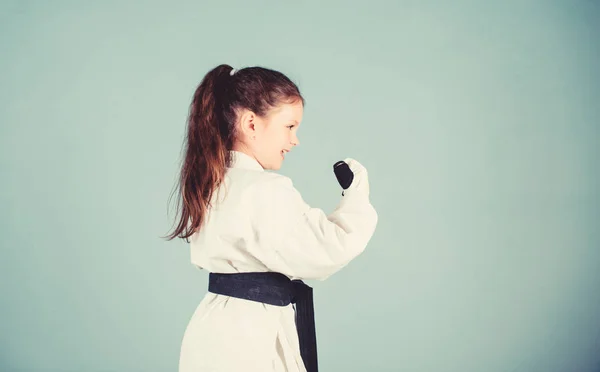 パワーとバランス。単一の戦闘でスポーツの成功。武道の制服を着た小さな女の子。カンフーを練習しています。幸せな子供時代。giスポーツウェアの小さな女の子。ノックアウト。子供のためのエネルギーと活動 — ストック写真