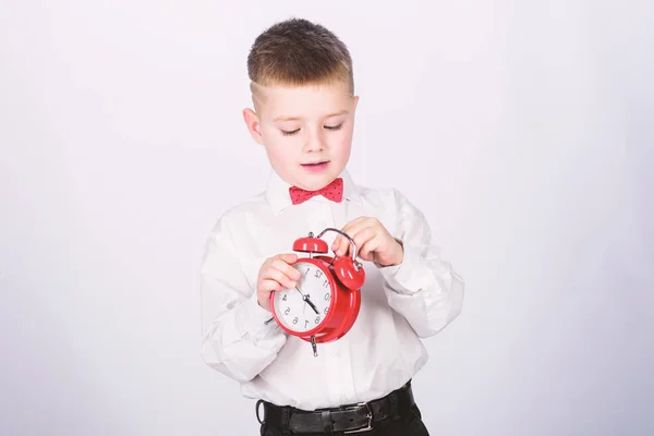 Zarządzanie czasem. Rano. mały chłopiec z budzikiem. Czas na relaks. szczęśliwy dziecko z zegarem retro w muszki. Tuxedo Kid. Szczęśliwego dzieciństwa. Czas na imprezę. Biznesmen. Odzież Formalna. Dzień rozpoczęcia — Zdjęcie stockowe