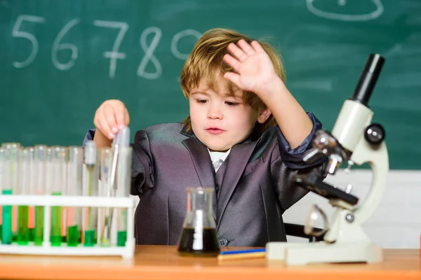 Μεγαλοφυές μωρό. Αγόρι κοντά στο μικροσκόπιο και δοκιμαστικούς σωλήνες στη σχολική τάξη. Τεχνολογία και επιστήμη έννοια. Το παιδί σπουδάζει βιολογία και χημεία στο σχολείο. Σχολική εκπαίδευση. Εξερεύνηση βιολογικών μορίων — Φωτογραφία Αρχείου