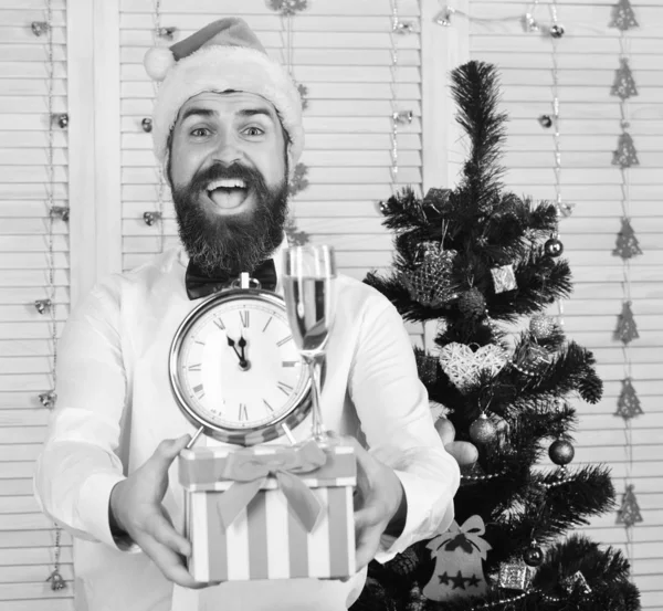 Guy near Christmas tree on wooden wall background. — Stock Photo, Image