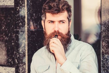 Sakallı vahşi erkek elektronik sigara içiyor. Sakallı olgun hipster. Sağlık güvenliği bağımlılığı. buharı teneffüs. adam sigara e-sigara. hipster adam vaping cihazı tutun. Sakallı adam vape içiyor
