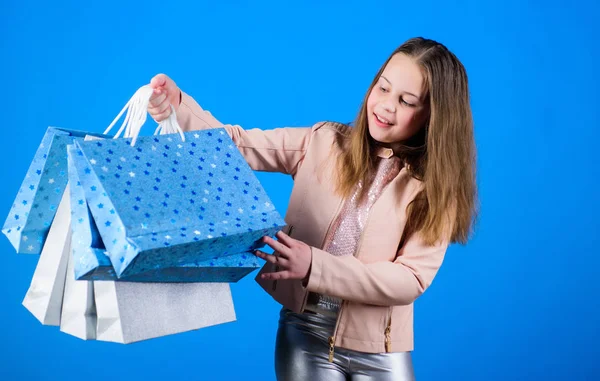 Happy child in shop with bags. Shopping day happiness. Buy clothes. Fashionista addicted buyer. Birthday girl shopping. Fashion boutique. Fashion trend. Fashion shop. Little girl with bunch packages — ストック写真