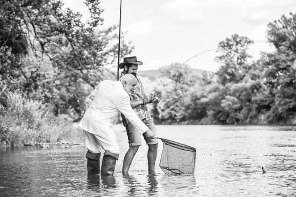 Friends fishing. Perfect weekend. Successful catch. Elegant bearded man and brutal hipster fishing. Hobby and recreation. Relax in natural environment. Summer vacation. Family day. Fishing team