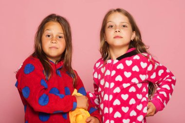 Çocuklar şüpheli yüzleri ve bağsız kıl ile. Kızlar pijama