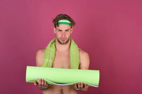 Mannen med naken överkropp innehar yogamatta på lila bakgrund — Stockfoto