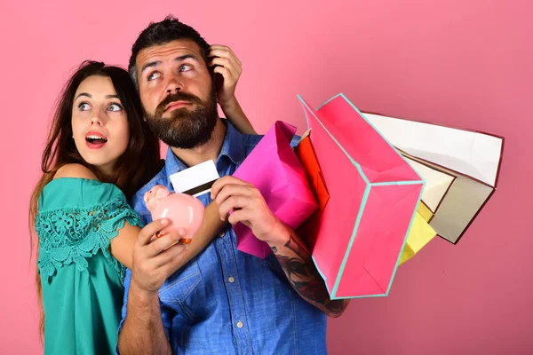 Pareja sostiene bolsas de compras y abrazo sobre fondo rosa . — Foto de Stock
