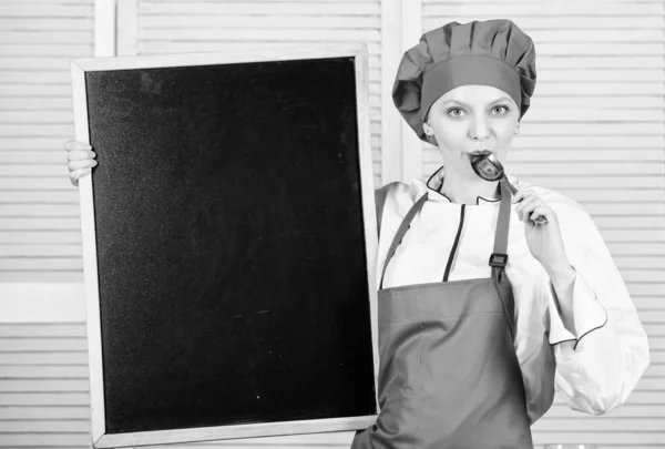 展示她的知识和技能。厨师大师上烹饪课。可爱的女孩拿着勺子在黑板上。烹饪学校的烹饪教育。首席厨师教大师班, 复制空间 — 图库照片