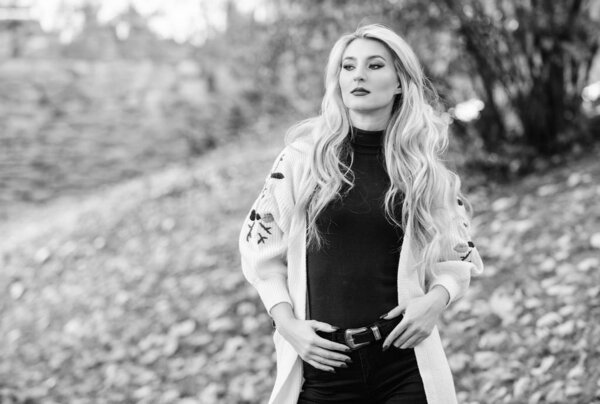 Как быстро и безопасно восстановить отбеленные волосы. Осенний уход за волосами важно, чтобы избежать сухих кудрявых волос. Девушка модная блондинка гуляет в осеннем парке. Длинный уход за волосами. Концепция холодной блондинки
