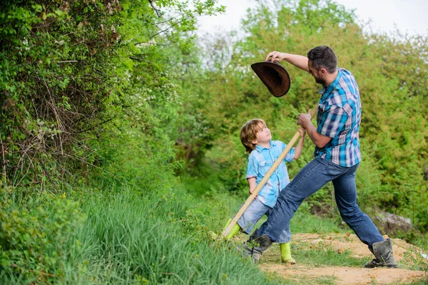 Little helper in garden. Cute child in nature having fun cowboy dad. Find treasures. Little boy and father with shovel looking for treasures. Spirit of adventures. Adventure hunting for treasures