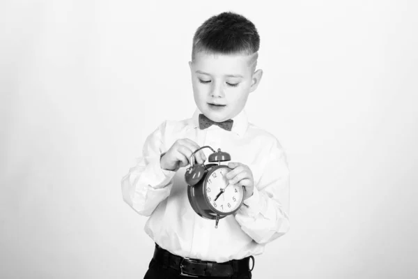 Gestión del tiempo. Buenos días. niño pequeño con despertador. Es hora de relajarse. niño feliz con reloj retro en corbata de lazo. Esmoquin. Feliz infancia. Hora de la fiesta. Empresario. Ropa formal. Día de inicio — Foto de Stock