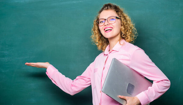 Программы для учителей. Женщина очаровательный учитель держать ноутбук стоять рядом с доской. Современное образование. Возвращайся в школу. Преподаю информатику. Школьное образование. Школьный преподаватель по теме
