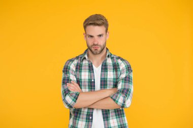 Erkek güzellik standartları. Erkeksi kıyafetler ve bak. Şık giyinmiş şık bir erkek. Kareli gömlek ve kot pantolon giymiş yakışıklı bir adam. Kendine güveni olan sarı öğrenci. Erkekler için gündelik moda