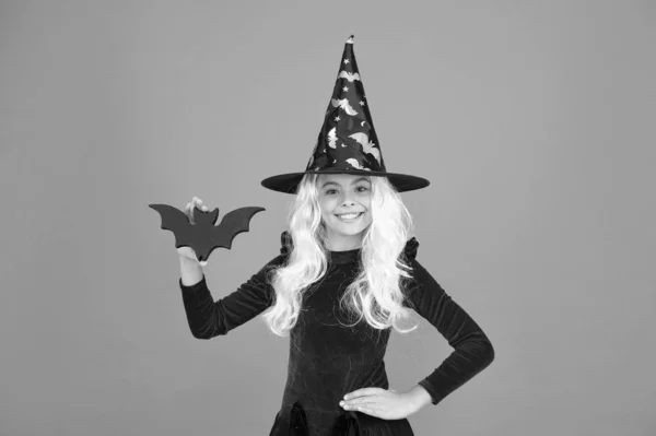 Бэт мой друг. Маленькое дитя в костюме ведьмы. Хэллоуинская вечеринка. Маленькая девочка в черной колпаке. Осенний праздник. Присоединяйся. Волшебное заклинание. Маленькая ведьма с белыми волосами. Волшебник или волшебник — стоковое фото