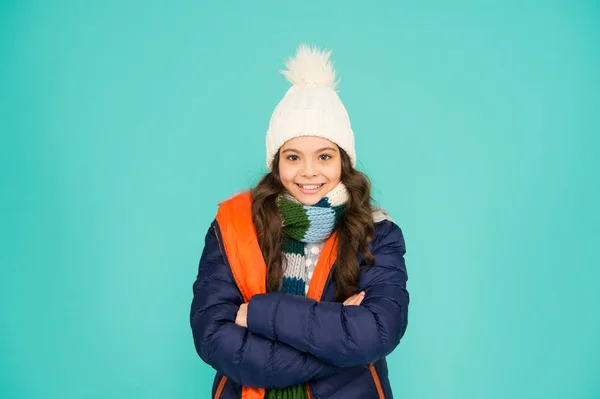 Si sente sicura di sé e carina. Bambino fiducioso tenere le braccia incrociate sfondo blu. Ragazza felice con un sorriso sicuro. Godersi l'inverno con stile. Fiduciosa nella sua protezione dal freddo invernale — Foto Stock