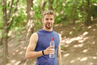 Küçük bir mola. egzersiz sonrası ferahlatıcı vitamin içeceği. su şişesi ile atletik adam. Atlet parkta eğitimden sonra su içmek. bakım vücut hidrasyon. spor ve sağlık. spor giyim adam içecek su