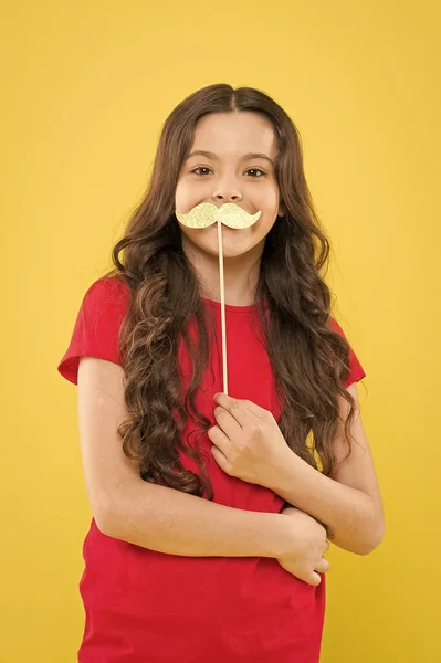 lets be funny. party elements. happy childhood. small kid yellow background. cheerful child with beautiful long hair. little beauty. birthday party time. smiling little girl party moustache