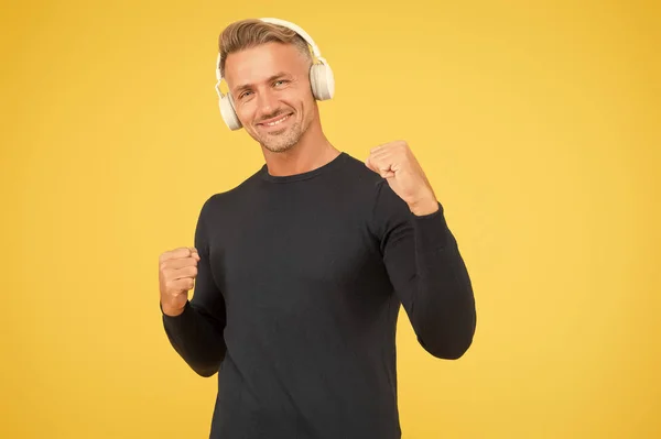 Libertad en la radio. Audio libro. La radio es moderna. Sonido limpio. Tecnología moderna. Hombre maduro escuchar música inalámbrica gadget fondo amarillo. Hipster feliz usando auriculares inalámbricos modernos —  Fotos de Stock