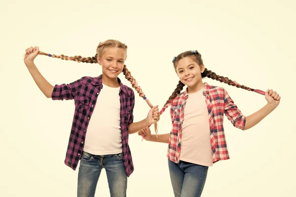 Делать милые и легкие прически. Счастливые дети держат длинные плетеные волосы. Маленькие девочки улыбаются в стиле моды. Сохраняй стиль. Мода и красота. Парикмахерская — стоковое фото
