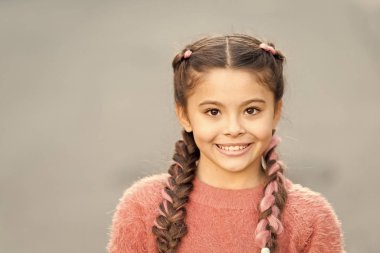 Keyif konsepti. Taze görünüşü ve cildi olan güzel bir çocuk. Uluslararası Çocuk Günü. Mutlu bir çocukluk. Mutlu ve pozitif. Dışarıdaki sevimli yüzlü çocuk gülüşü. Saçlarını ören mutlu küçük kız