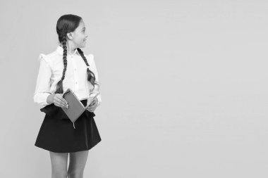 Dil ve edebiyat öğreniyorum. Sarı arka planda çocuk edebiyatı kitabı tutan şirin küçük bir çocuk. İngiliz edebiyatı dersine hazırlanan küçük kız. Okul edebiyatı, kopyalama alanı