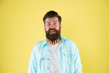 Adam sakallı mandal. Kalpleri mandallı vahşi bir hippi. Sakallı adam sıradan sarı arka plan. Sevgililer Günü. Kuaförde saç kurutma. erkek için bireysel saç şekli