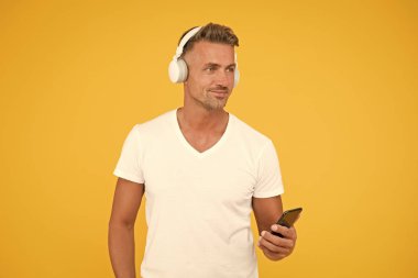 Dinleme konsepti. En iyi müzik uygulamaları. İyi bir şarkı dinle. Guy modern kullanıcı mobil uygulaması. Favori müzik listesi. Müzik aboneliği. Olgun erkek müzik dinler modern kulaklıklar ve akıllı telefon