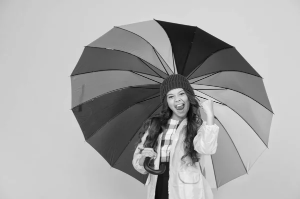 Concept de positivité. Amusant jour de pluie. Bonne promenade sous le parapluie. Profitez du concept de pluie. Enfant fille heureux tenir parapluie arc-en-ciel coloré. Météo pluvieuse avec des vêtements appropriés. Parapluie lumineux. Amuse-toi. — Photo