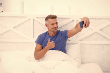 İyi sabahlar. İnternet günlüğü içeriği. Kişisel blog konsepti. İyi sabahlar. Fotoğraflı akıllı telefon kullanan bir adam. Çevrimiçi video yayınlanıyor. Gezici internet. Blog için çekim. Olgun bir blogcu. Başparmak yukarı.