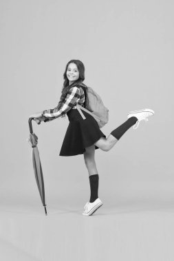 Yağmur koruması. Yağmura karşı şemsiyesi olan mutlu küçük çocuk. Şirin küçük okul kızı yağmurlu havalarda şemsiye kullanır. Sonbahar modası ve aksesuarı. Okul zamanı. Yağmurda durmasını sağlıyor.