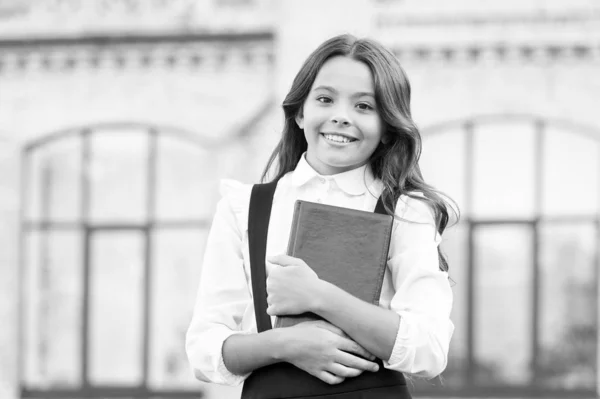 Aprendendo linguagem. Ligado à aprendizagem. Vida escolar. Desenvolvimento infantil. Entusiasmado por estudar. Conceito de educação escolar. Bonito livro infantil sorridente. Uma aluna de escola. Dia do conhecimento — Fotografia de Stock