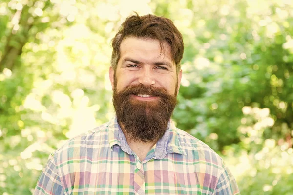 Sourire augmente le bonheur. Homme barbu au visage souriant et joyeux sur un paysage naturel. Un hipster souriant portant une moustache élégante et des poils de barbe le jour de l'été. Je suis toujours souriant et heureux — Photo