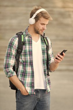 E öğrenme. Üniversite öğrencisi kulaklık akıllı telefon. Online öğrenme. Sesli kitap konsepti. Öğrenmeyi kolaylaştırmak için hem fiziksel donanım yazılımının hem de eğitici kuramsal eğitimin teknoloji kullanımı