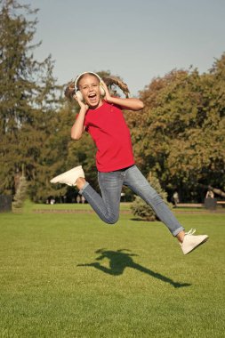 Mükemmel yüksek sesli ses. Hiç bitmeyen neşe. Müzik dinleyen kız, modern alet. Çocuk, kablosuz kulaklıkla dans edip zıplamaktan memnun. Stereo kulaklık. Çocuk modern teknolojiyi kullanıyor. Modern çocuk