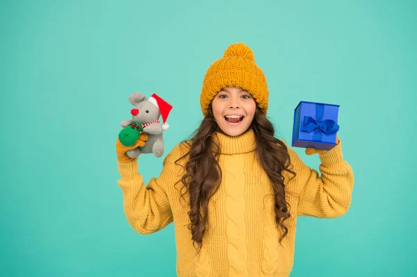 小女孩拿着老鼠玩具和礼物盒。孩子们的针织衣服和玩具老鼠玩耍。儿童玩具商店。圣诞节来了。圣诞节是最受欢迎的寒假。新的2020年快乐。可爱的桑塔老鼠玩具礼物 — 图库照片