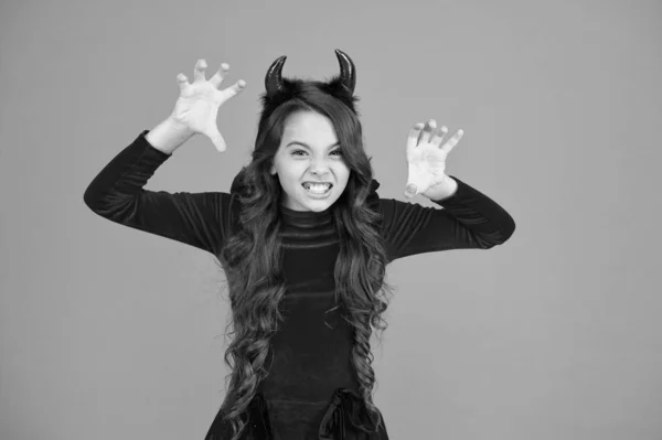 Halloween costumes designed after supernatural figures. Little devil. Little girl red horns celebrate Halloween. Carnival concept. Small child with imp style accessory Halloween party. Trick or treat