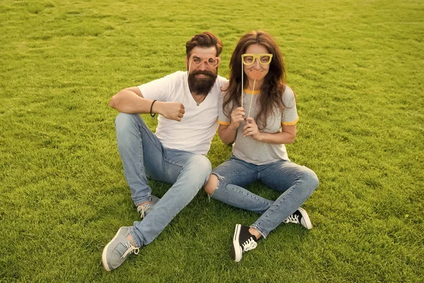 Hacer que San Valentín sea divertido. Pareja enamorada sosteniendo accesorios de fiesta de San Valentín en palos. Hipster y chica sexy mirando a través de gafas de lujo para el día de San Valentín. Celebrando el día de San Valentín juntos —  Fotos de Stock