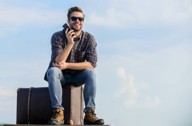 Ulaşım tesisleri. Taksi çağırıyorum. Seyahat acentesi. Bagajla seyahat et. Gezgin blogcu. İnsan yolculuktan önce bavula oturur. Bagaj konsepti. Yakışıklı gezgin. Klasik bavullu bir adam.