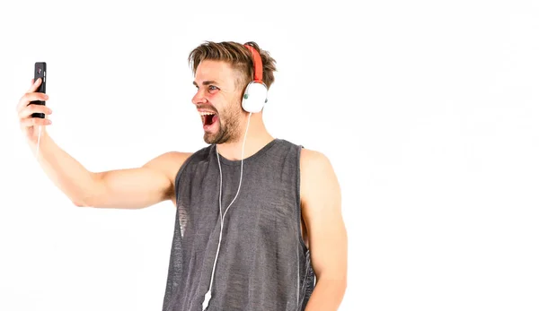 Faire du selfie. communication par appel vidéo. homme musclé sexy écouter audio. homme dans les écouteurs isolé sur blanc. Le livre. homme non rasé écoute livre audio — Photo