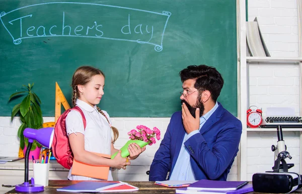 Prendi questo. regalo di fiori per la migliore insegnante. Torniamo a scuola. Buona giornata degli insegnanti. Giornata degli insegnanti. Daugghter e papà con i fiori. giorno della conoscenza 1 settembre. bambino piccola scuola ragazza con mazzo di fiori — Foto Stock