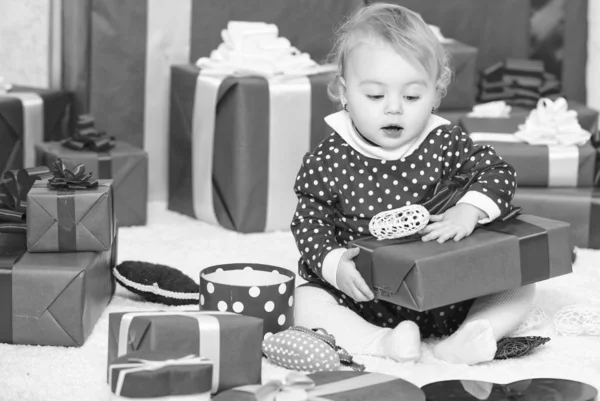 Первое рождество ребенка раз в жизни. Маленькая девочка играет рядом с кучей подарочных коробок. Подарки для первого ребенка. Отпразднуй первое Рождество. Радость первого рождества с семьей — стоковое фото