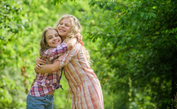 Filles enfants meilleurs amis câlin. Amour et soutien de la fraternité. Bonne enfance. Un concept de câlin et d'amour. Enfants heureux ensemble fond de la nature. Une vraie amitié. Les filles souriant heureux visages étreindre l'autre — Photo