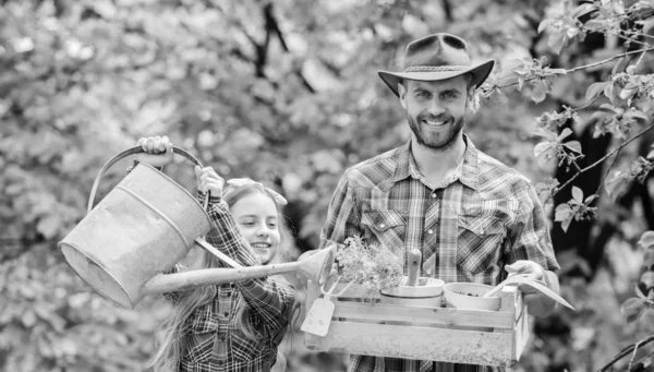 Pai e filha no rancho. menina e pai homem feliz. Dia da Terra. Primavera aldeia país. ecologia. Rega e pá. Fazenda familiar. A trabalhar em estufa. Florista no trabalho — Fotografia de Stock