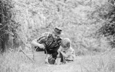 Bahçe aletleri. Çiçek dikiyorum. Babam küçük oğul bakım bitkileri öğretiyor. Bahçede küçük bir yardımcı. Gezegeni daha yeşil yap. Büyüyen bitkiler. Bitkilere iyi bak. Sulama ile doğada çocuk ve baba olabilir
