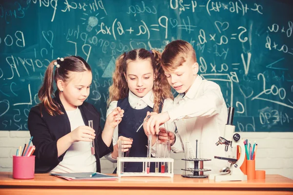 학교 수업에서 어린 아이들. 학교 실험실에서 화학을 배우는 어린 아이들. 화학. 학교로 돌아갑니다. 현미경으로 생물학 실험을 하는 학생들. 어린이날. 자신감 있는 의사 팀 — 스톡 사진